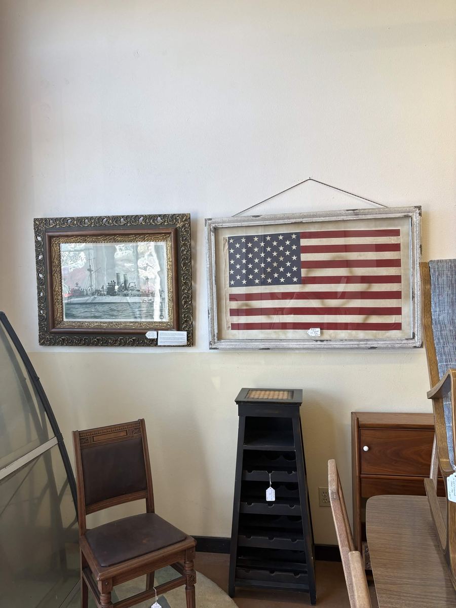 Antique 48 star American flag framed beside a battleship print