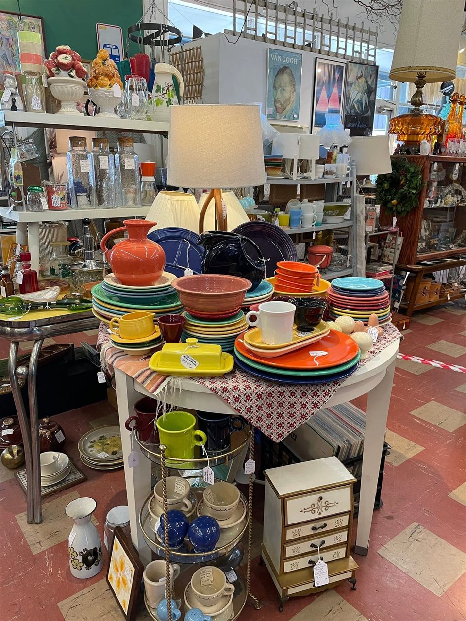 Table stacked with colorful Fiesta ware plates, bowls, and pitchers
