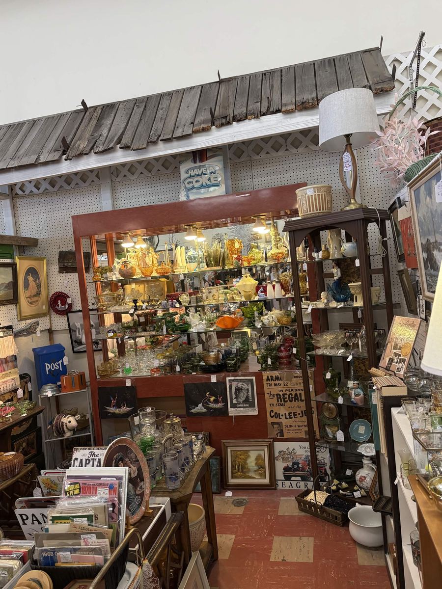 Lit display case full of amber, green, and vintage glassware