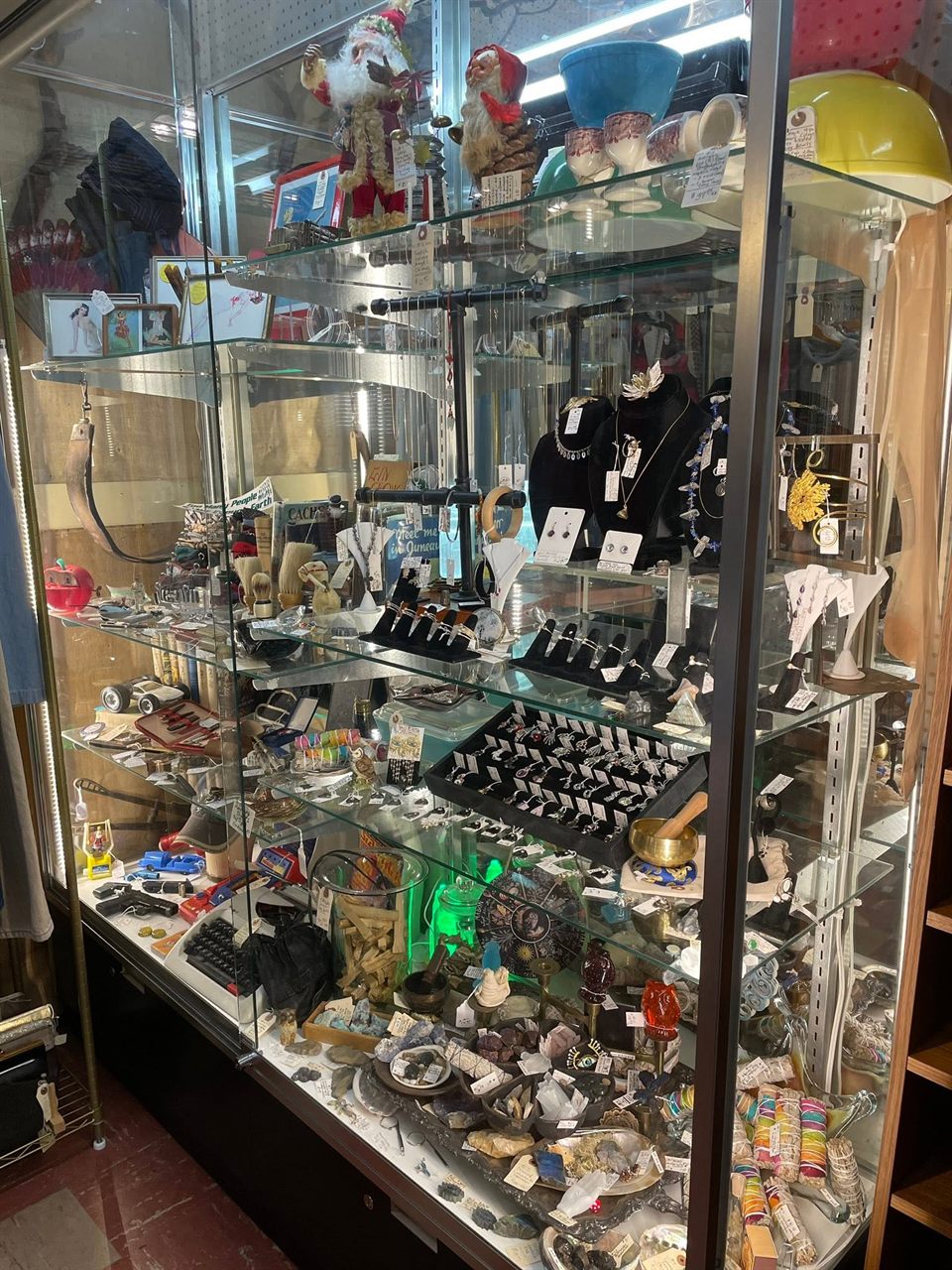 Lit glass case full of rings, necklaces, and vintage jewelry