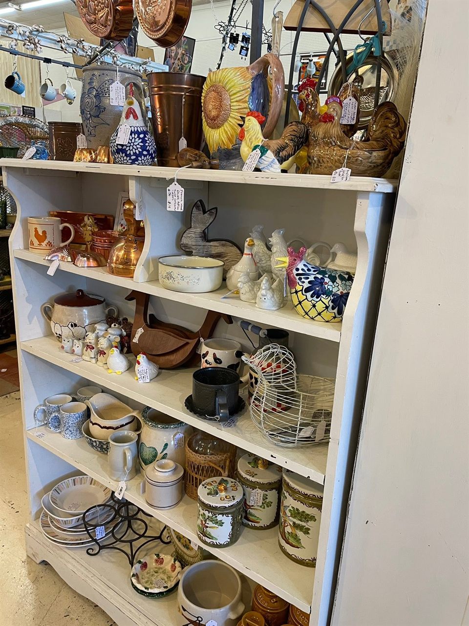 Country hutch with ceramic roosters, copper molds, crocks, and canisters