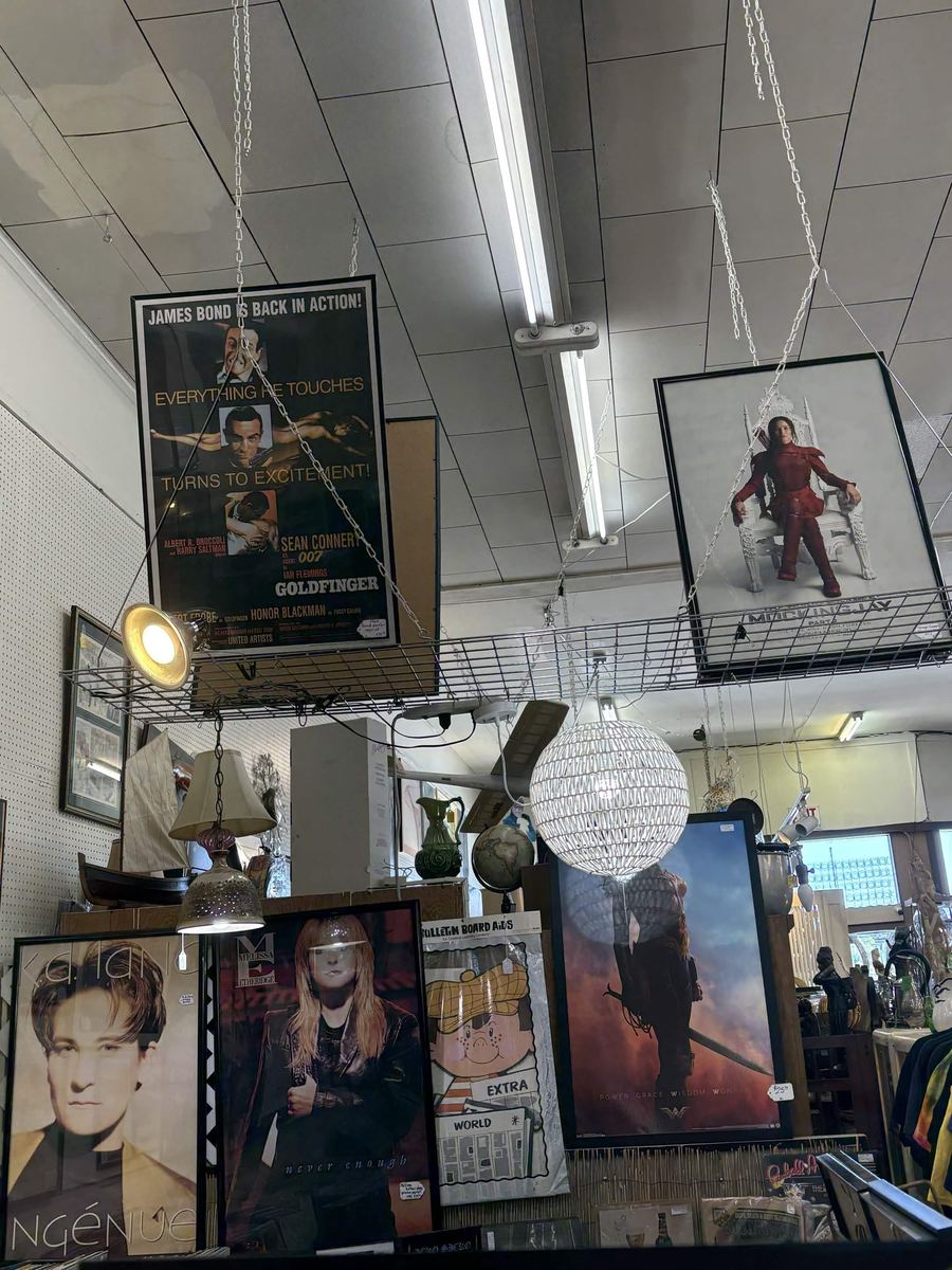 Framed movie and music posters hanging from the ceiling including Goldfinger