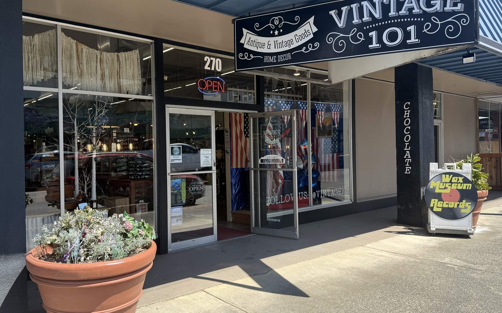 The Vintage 101 storefront on South Broadway, with its blue and white sign, antiques in the windows, and the Wax Museum Records sign out front